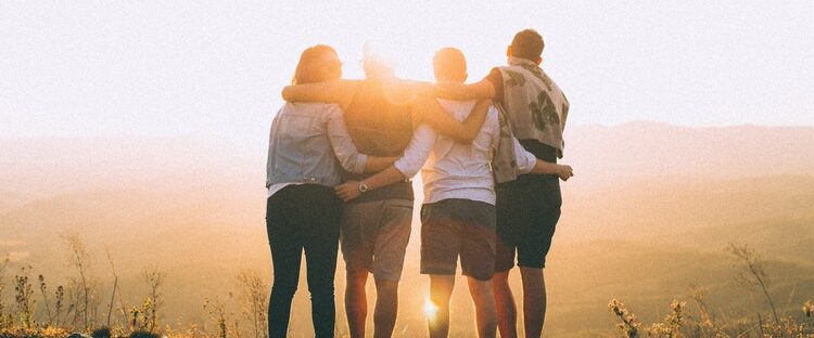 Group of friends looking out into the sun outside of a sober living home