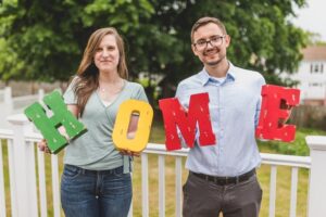 Man and woman holding up home blocks for sober living house