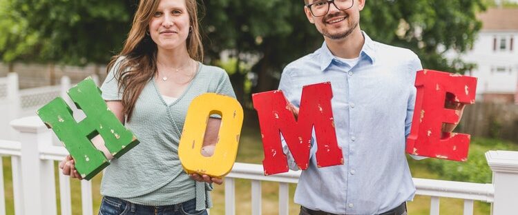 Man and woman holding up home blocks for sober living house